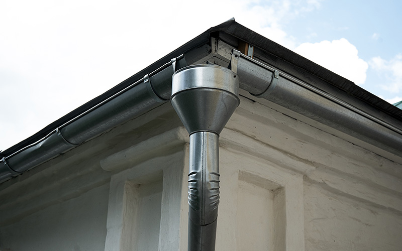 metal rain gutter system with downspout on a building roof six drainage solutions